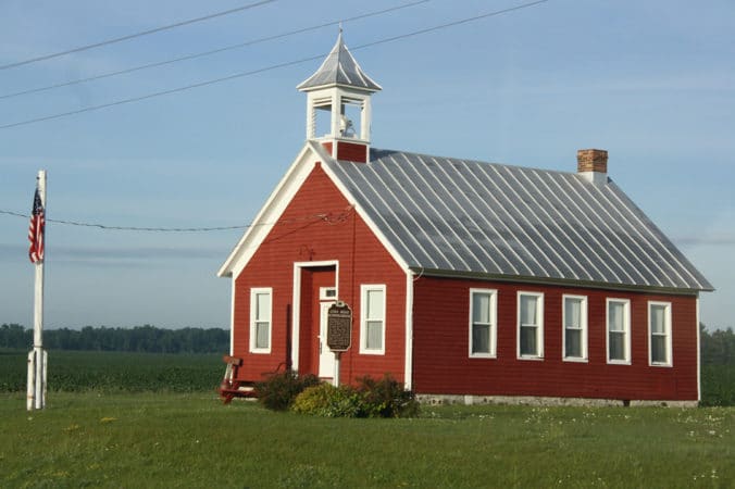 草原にある赤レンガの建物の写真