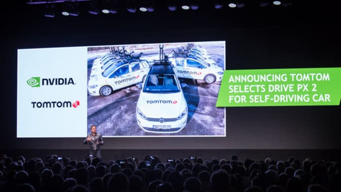 TomTom のプレゼンテーションを背に講演する NVIDIA の共同創立者兼 CEOジェンスン・フアンの画像
