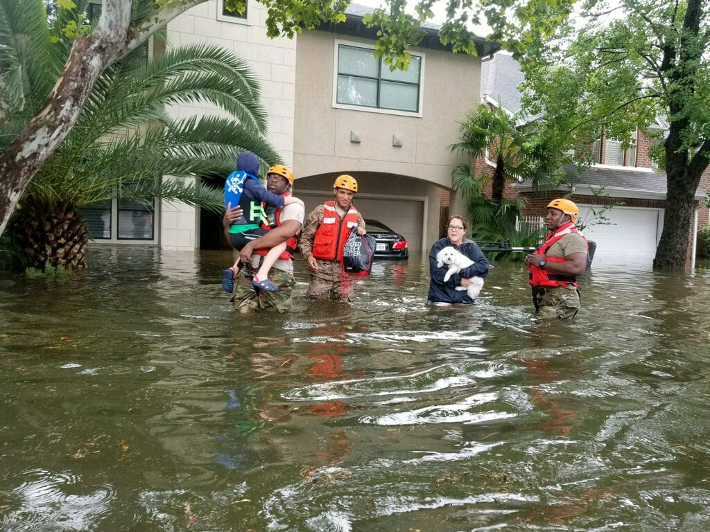 Members of the Texas National Guard rescue a family from a flooded house. Earlier hurricane predictions could help keep people out of harm's way.