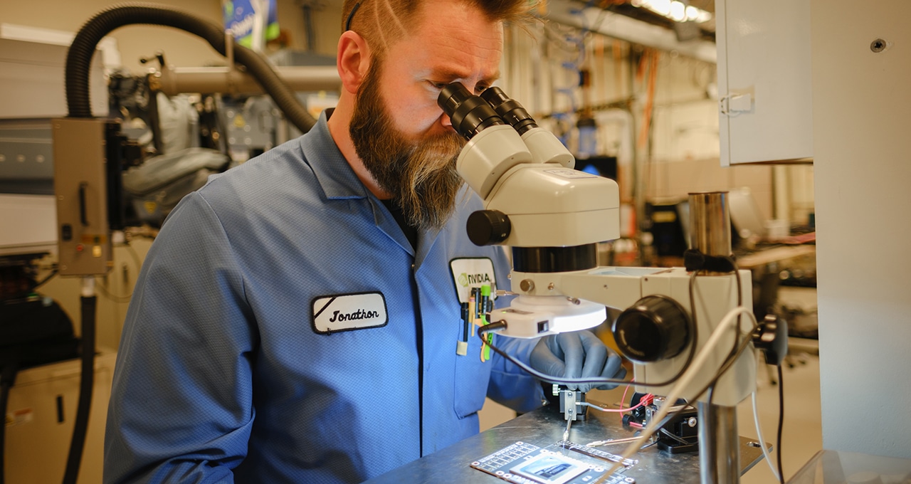 Failure analysis engineer inspects a chip under a microscope.