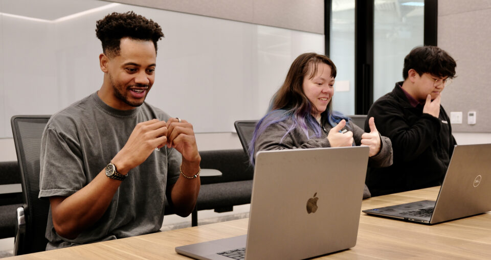 Three people practicing sign language using Signs AI platform