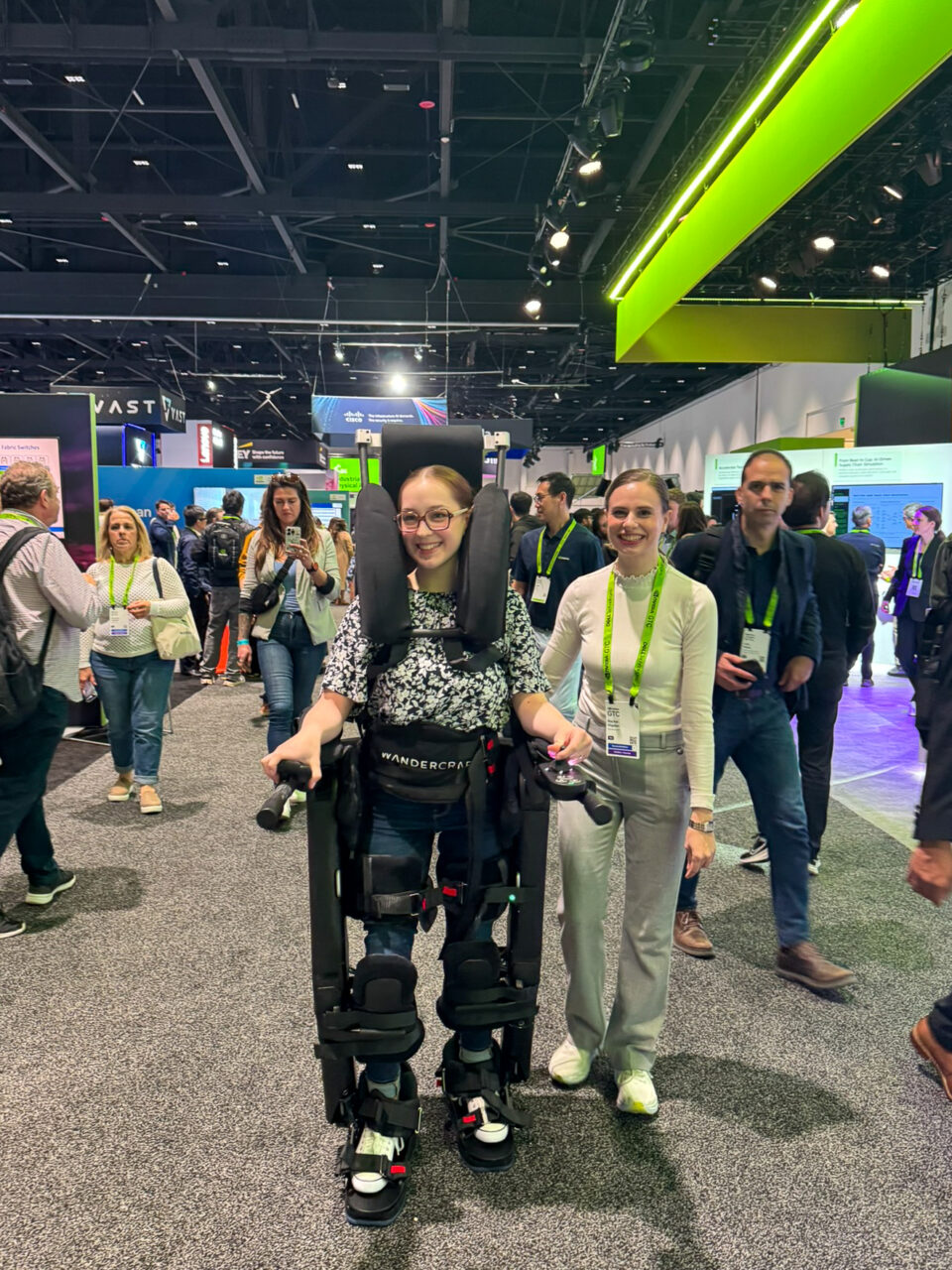 Woman walking through conference exhibit hall using AI exoskeleton