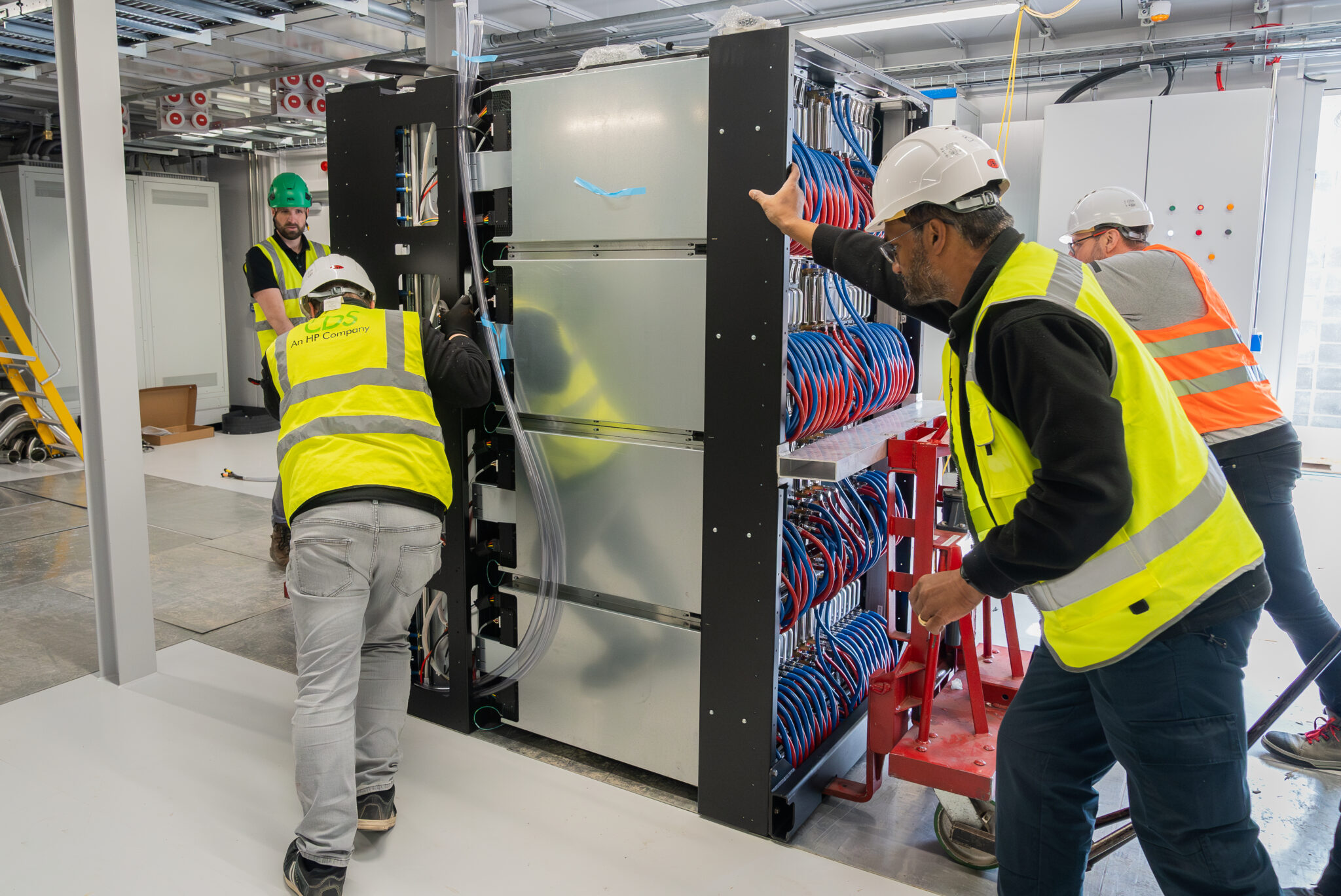Engineering teams working collaboratively to maneuver and install components, illustrating the complex and coordinated effort behind the build.